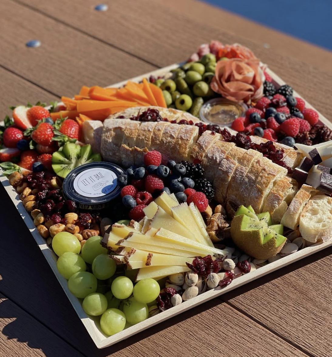 Large Let It Brie grazing board with cheeses, berries, baguette and charcuterie roses